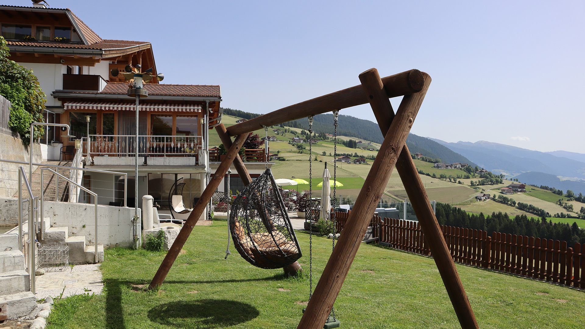 Garten der Pension Wiesenrain mit Schaukel, Panoramablick auf die Dolomiten und das Pustertal.