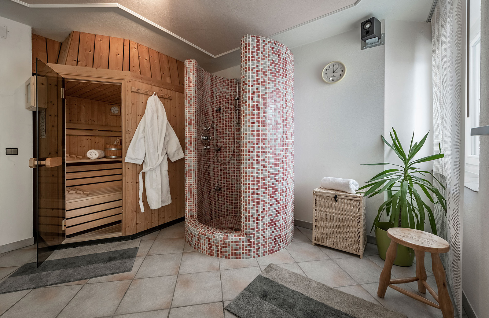 Private wooden sauna with a white bathrobe and a mosaic shower, for regenerating relaxation at Pension Wiesenrain.